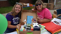 Teachers holding a box of school supplies