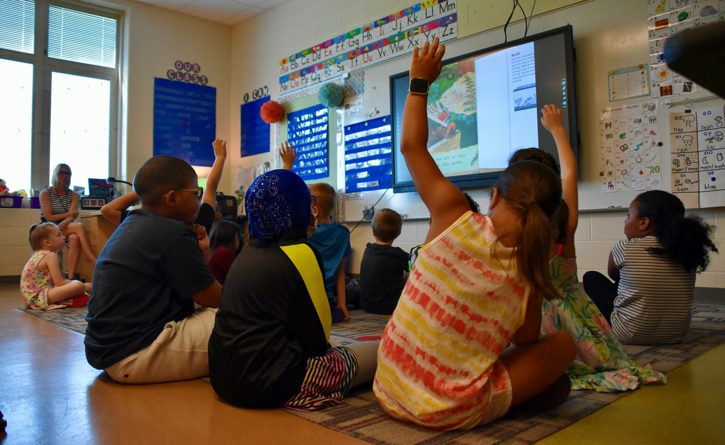 Students raise hands to answer a question