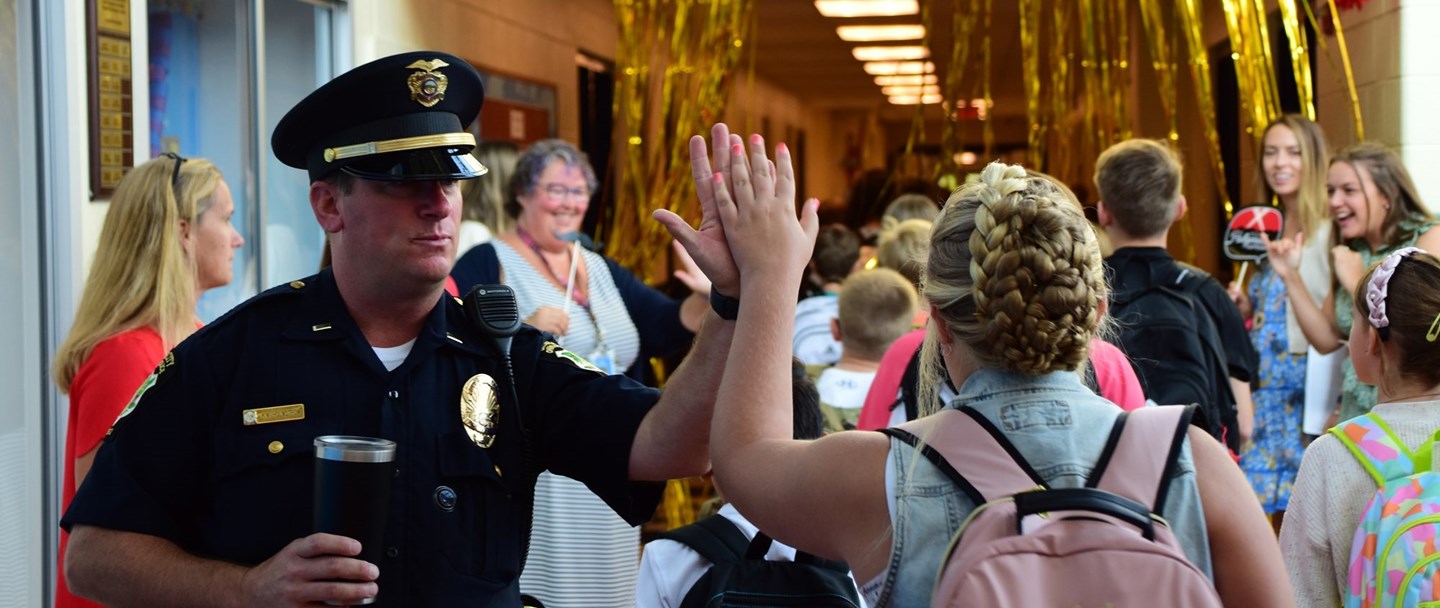 Cop high fiving a student